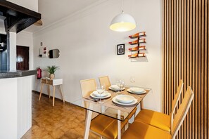 A dining area with a glass table, wooden chairs, and a hanging light fixture. - Inema Houses Amazing Sea View (Lagos)