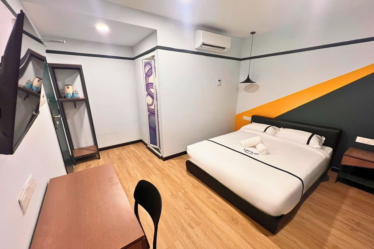 Une chambre d’hôtel équipée d’un lit, d’un bureau, d’une chaise, d’une armoire et d’un appareil de climatisation.
