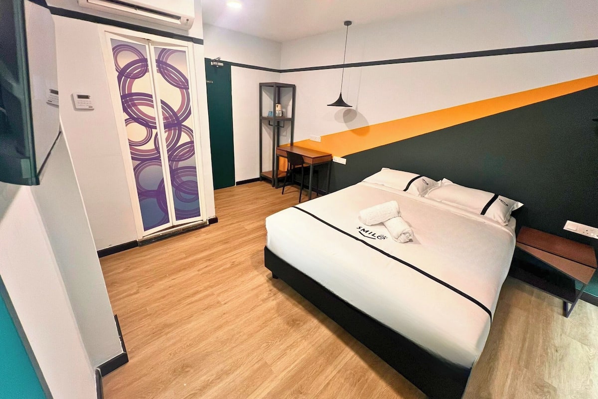 Une chambre d’hôtel moderne équipée d’un lit, d’un bureau et d’une armoire.