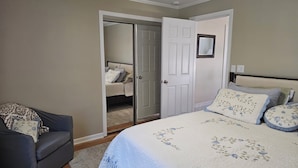 A bedroom with a bed, a chair, a wardrobe, and a door leading to another room. - Quiet 2bd 1ba ranch with off street parkingWalking distance to downtown/beach. (Lake Geneva)