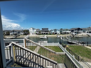 Propiedad frente al agua con muelle, barcos y casas con balcones.