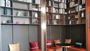 Een moderne bibliotheek met boekenplanken, zitgedeeltes en een ronde tafel.