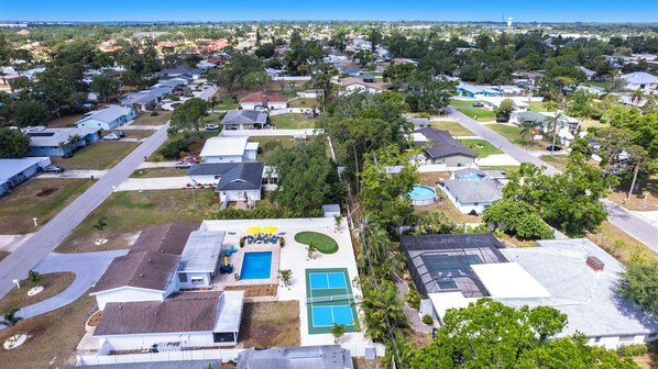 A residential area with houses, a swimming pool, and a tennis court.