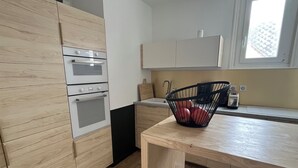 A kitchen with wooden cabinets, a black countertop, and a window.
