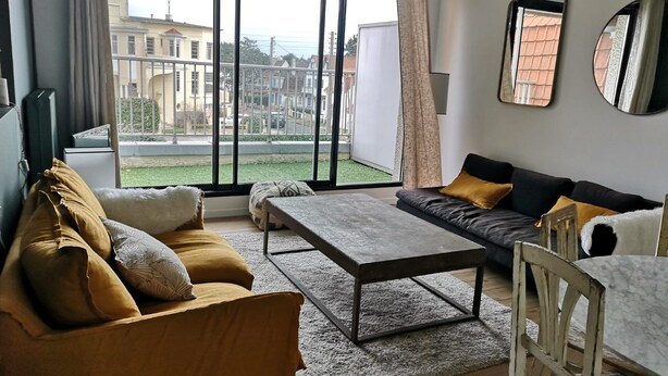 A modern living room with a sofa, a coffee table, and a dining table.