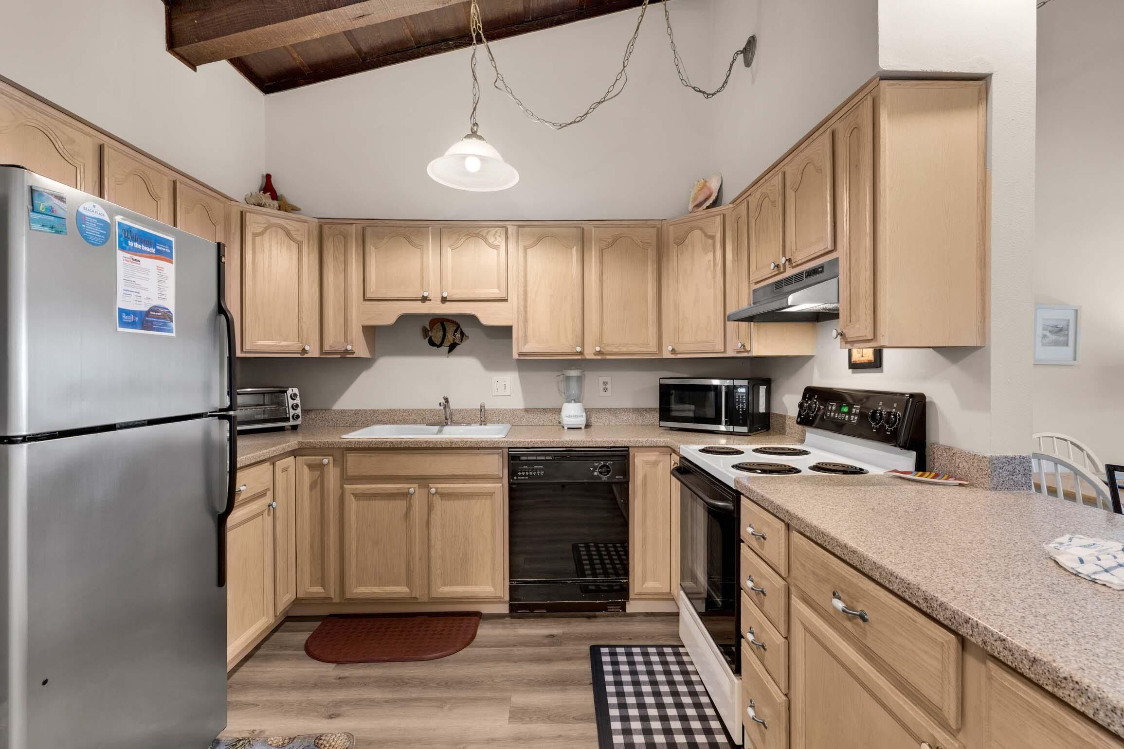 Una cocina con armarios de madera, electrodomésticos de acero inoxidable y encimera de granito.