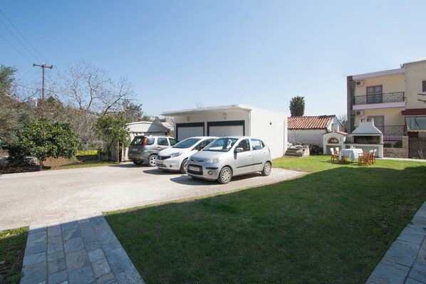 A residential area with a garage, parked cars, and a small outdoor seating area.