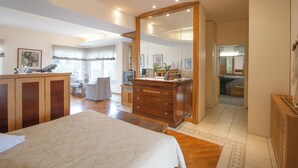 A spacious bedroom with a large bed, wooden dresser, and a walk-in closet. - villa penelope (Skiathos)