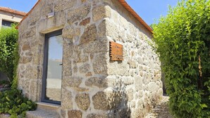 A stone building with a wooden sign reading 'Casa do Carvalho,' a door, and steps leading to the entrance.