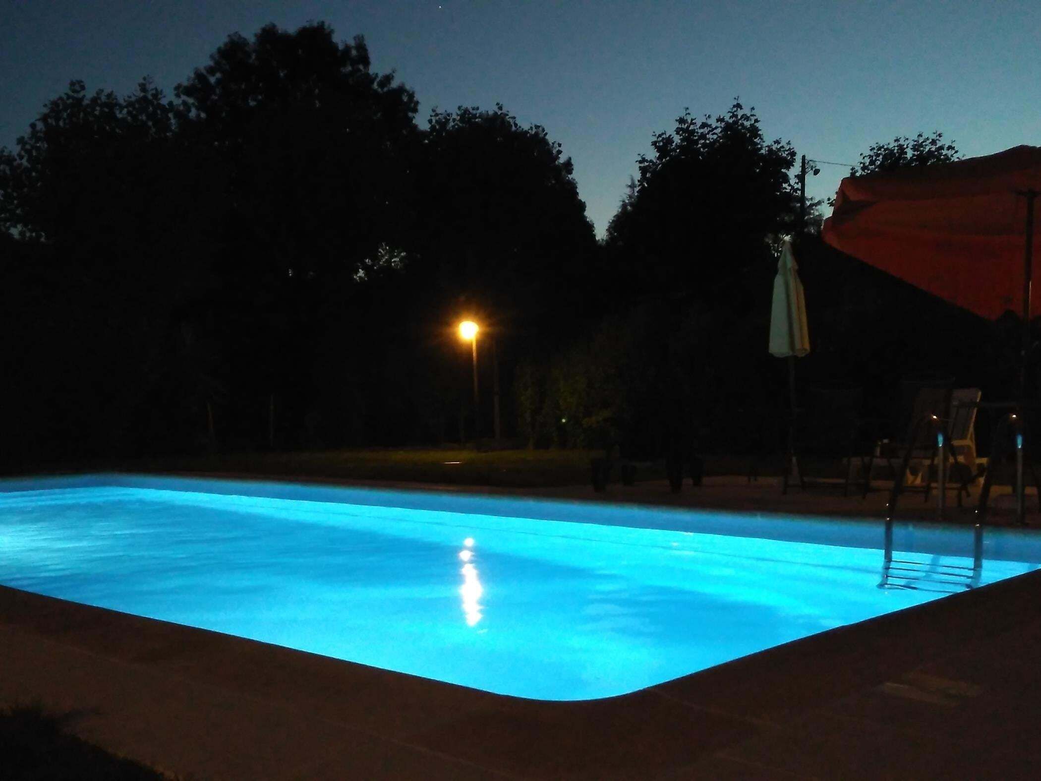Una piscina iluminada de noche.