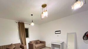 A modern living room with two sofas, a white desk, and a mirror. - Manzzel Dahab Hostel (Dahab)