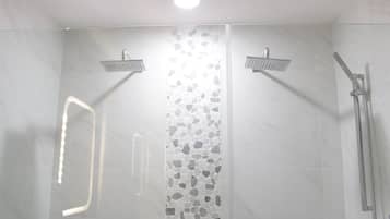 Een douche, handdoeken, zeep, toiletpapier
