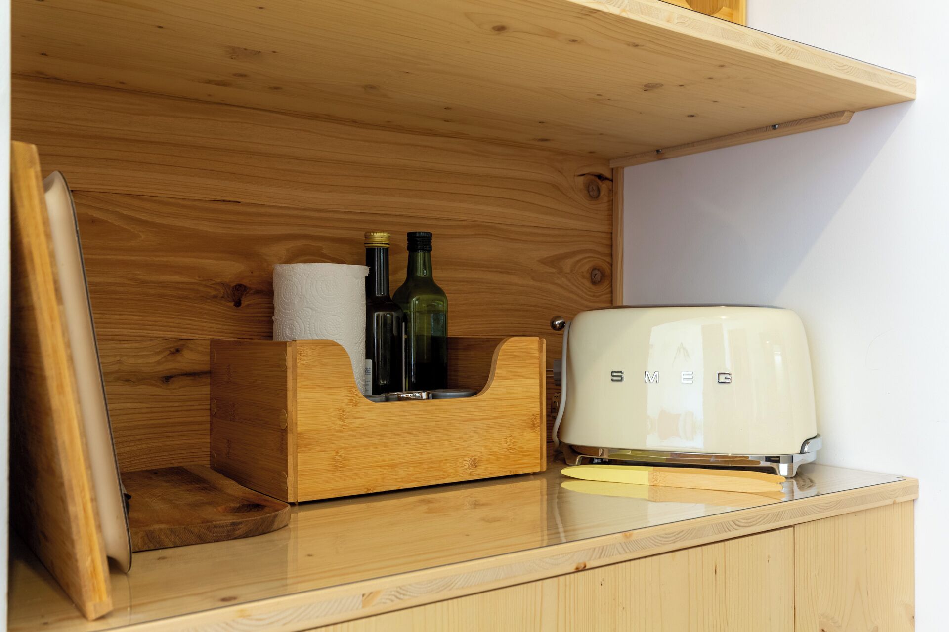 A wooden cabinet with a built-in toaster and a bottle holder.