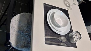 A dining table set with white plates, cutlery, and glasses, with framed artwork and a candle holder on the table. - Apartment near Hannibal Center (Bochum)