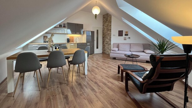 A modern loft apartment with a dining area, kitchen, and living space. - High Up Retreat (Linz)