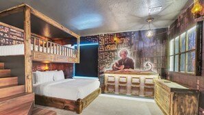 Une chambre avec un lit superposé, un bureau et une fresque murale.