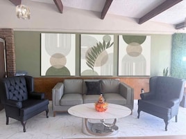 A modern living room with a sofa set, a coffee table, and abstract wall art.