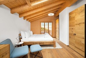 Cozy retreat with a sloped ceiling, large window, and comfortable bed.