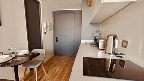 A compact kitchen with a black countertop, a built-in stove, and a coffee maker. - Confort de Fray Camilo 171 (Santiago)