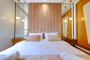A hotel room with a large bed, two bedside tables, a mirror, and pendant lights. - Calm and luxury (Marrakech)