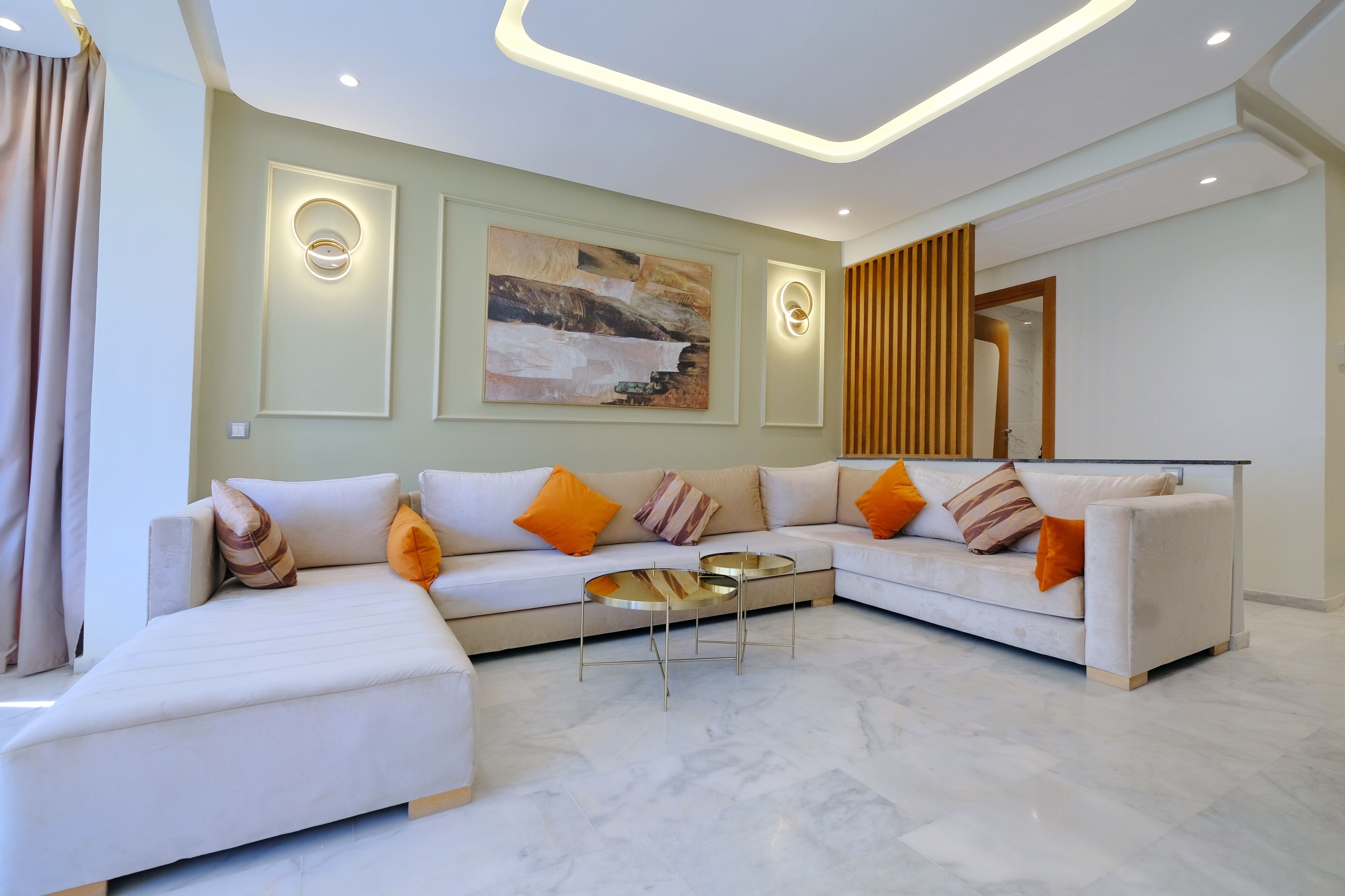A modern living room with a sectional sofa, a glass coffee table, and a painting on the wall.