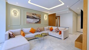 Uma sala de estar moderna com um sofá modular, uma mesa de centro e um quadro na parede.