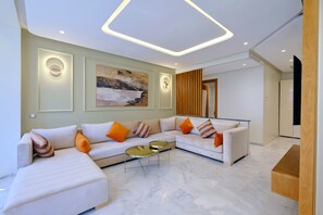 A modern living room with a sectional sofa, a coffee table, and a painting on the wall.