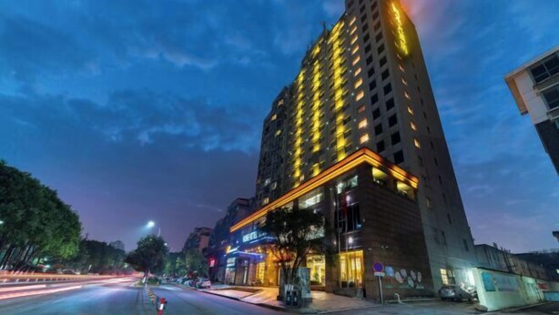 A high-rise hotel with multiple floors, illuminated windows, and a prominent entrance with a sign. - Huihe Hotel (Shangrao High Speed Railway Station) (Shangrao)