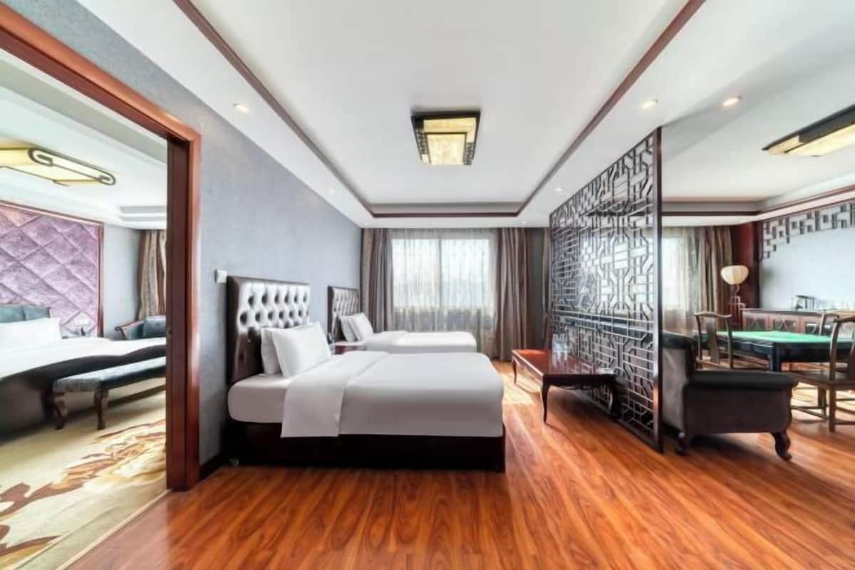 Une chambre d’hôtel avec un grand lit, un bureau et une table de billard.