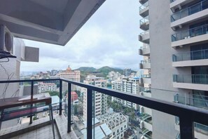 A balcony with a view of a cityscape, including buildings and a mountain. - Sanya Dadonghai Gediao House Apartment (Sanya)