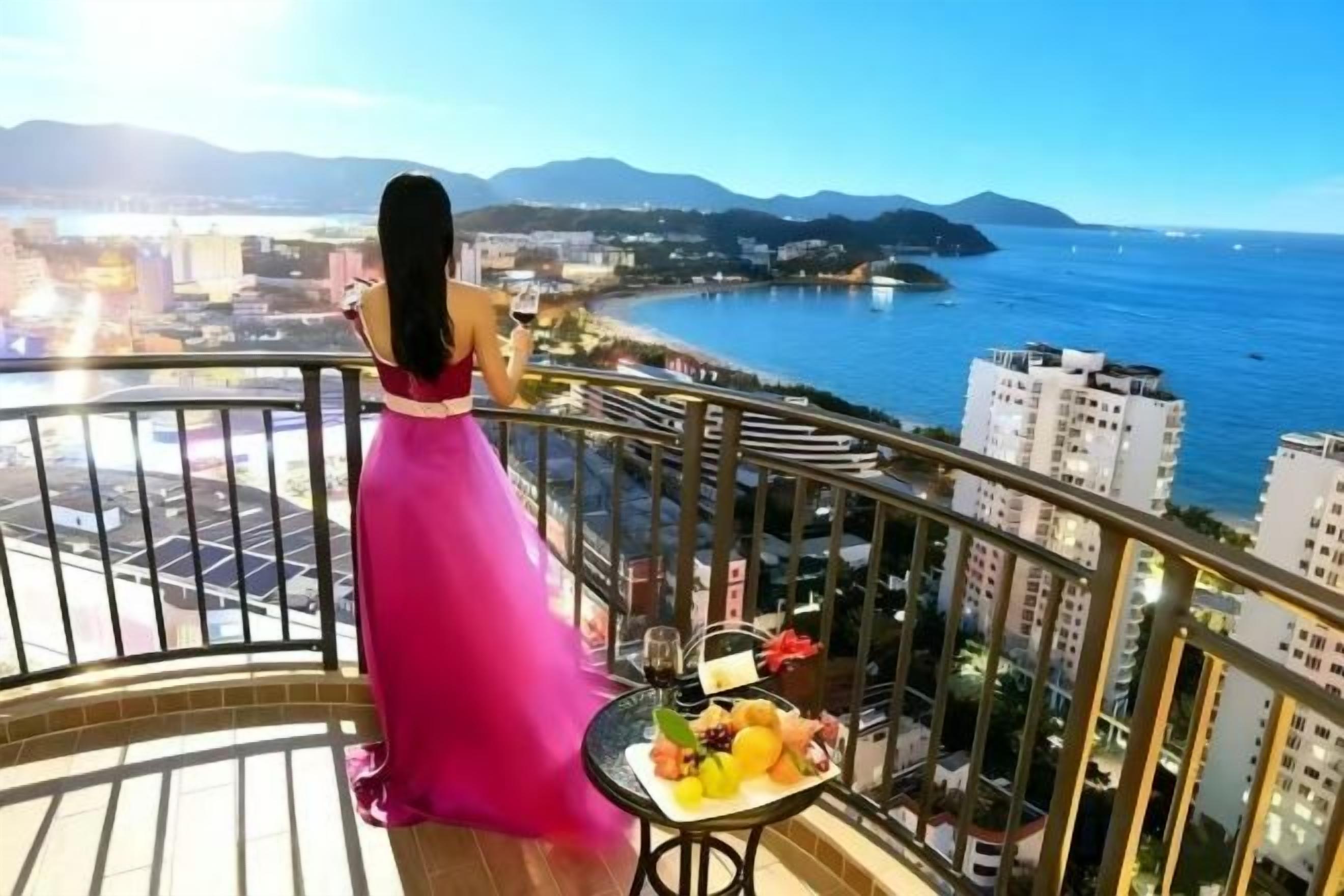 A balcony with a view of the sea and buildings.