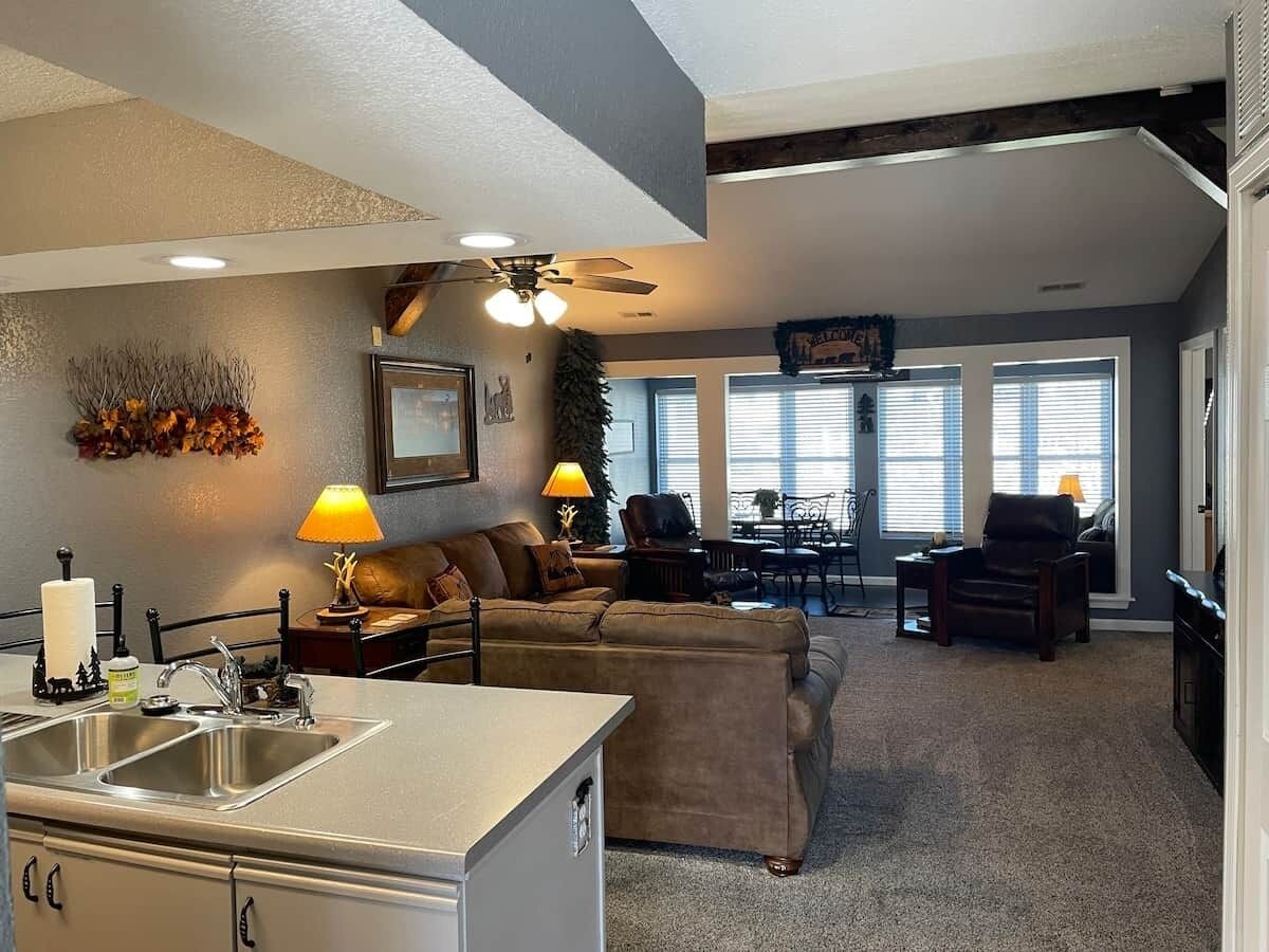 A modern living room with a sofa, a dining table, and a kitchen area with a sink and countertop.
