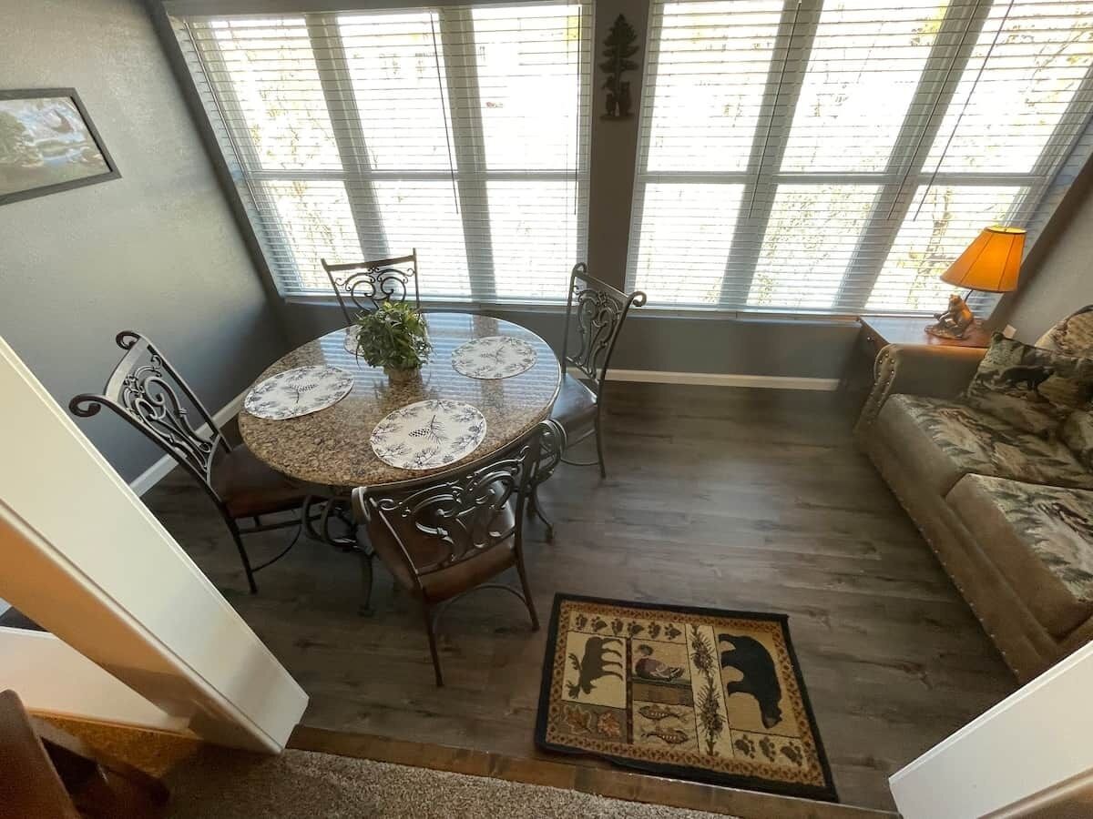 A dining area with a round table, chairs, and a decorative rug.