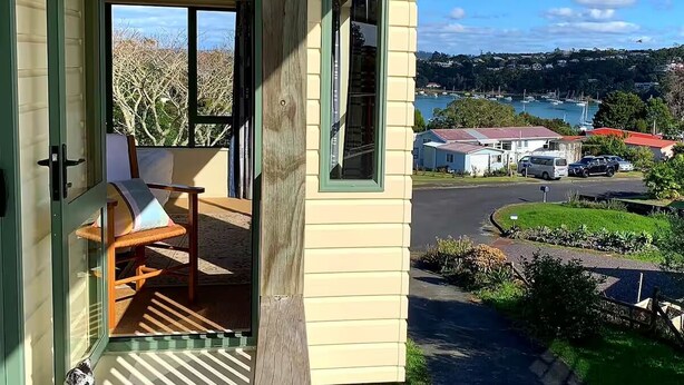 Un bâtiment jaune avec une chaise en bois devant.