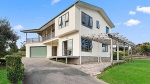 Une maison à deux étages avec un porche couvert et un garage.