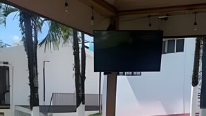 Uma área externa coberta com um caminho de ladrilhos que leva a um edifício.