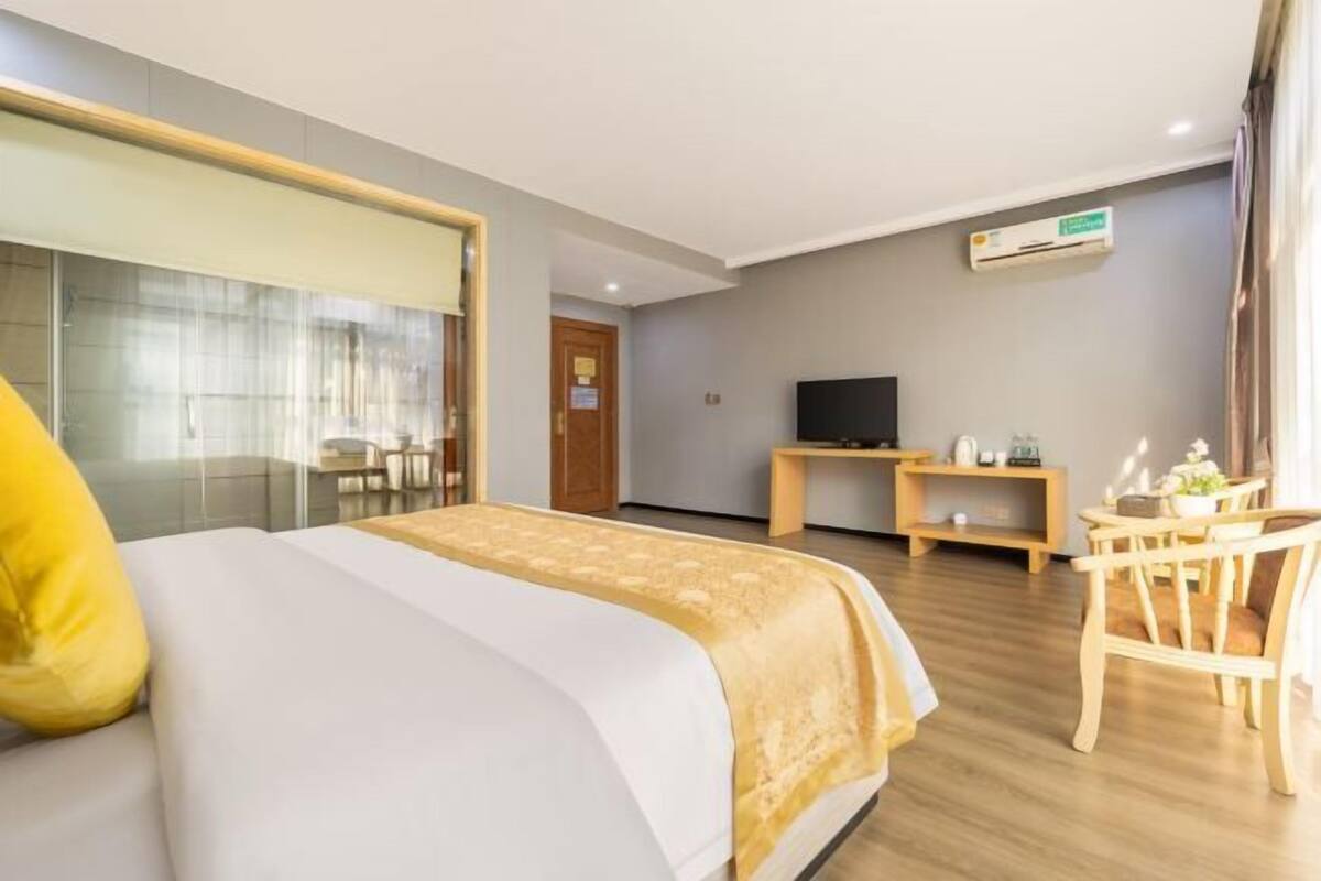 Een hotelkamer met een bed, een televisie, een bureau en een stoel.
