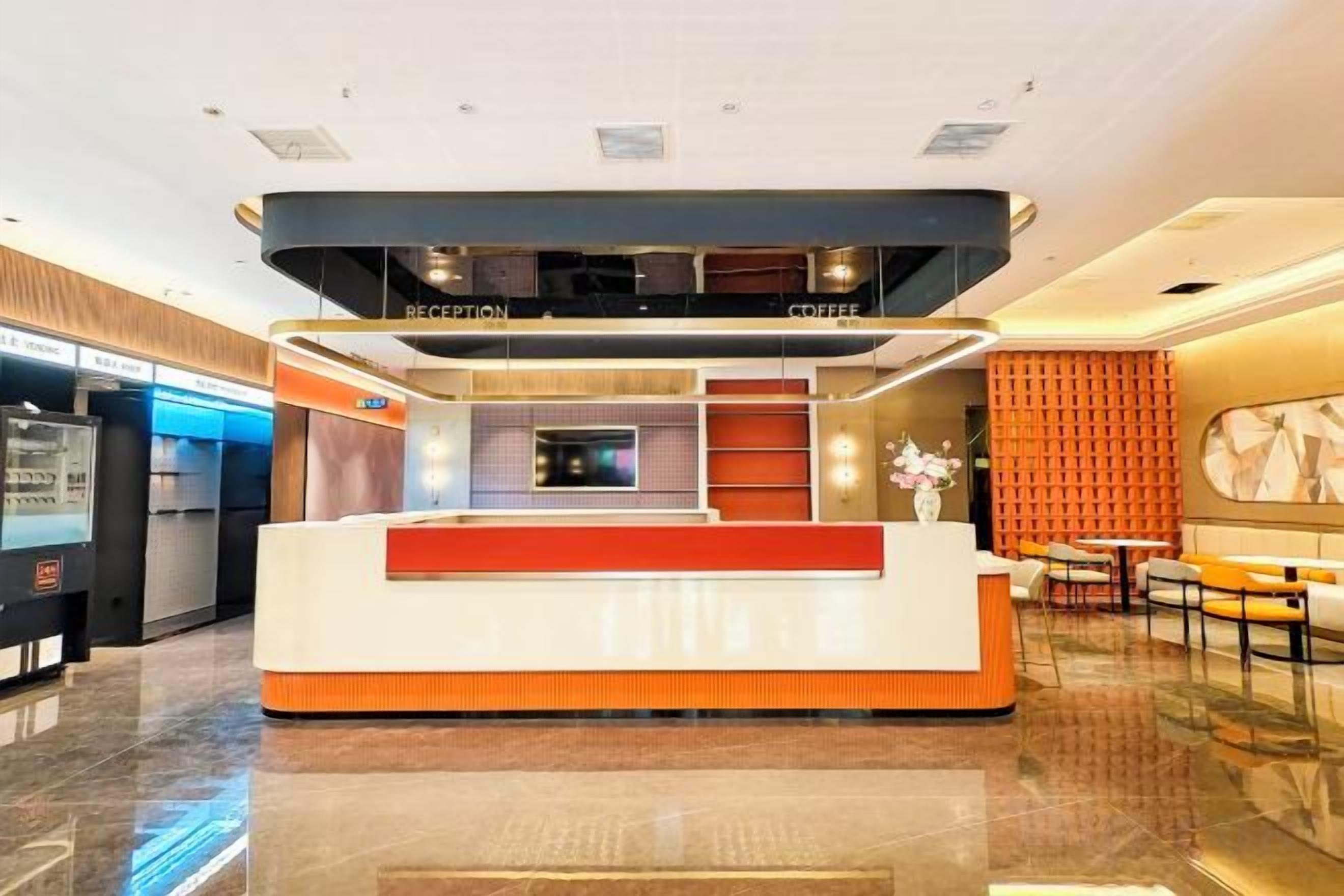 A hotel reception area with a reception desk, a coffee station, and seating area.