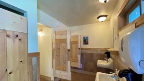 Une salle de bain avec des meubles en bois, un lavabo et un espace douche.