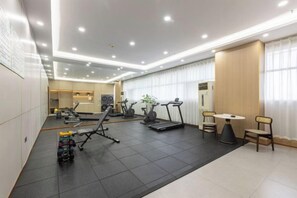A modern hotel gym with exercise equipment, a treadmill, and a dining area. - Rezen Anyi Hotel (Guangzhou Baiyun Railway Station) (Guangzhou)