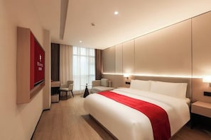 A hotel room with a large bed, a desk, a chair, and a TV. - Rezen Anyi Hotel (Guangzhou Baiyun Railway Station) (Guangzhou)