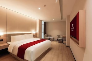A modern hotel room with a large bed, bedside tables, a desk, and a chair. - Rezen Anyi Hotel (Guangzhou Baiyun Railway Station) (Guangzhou)