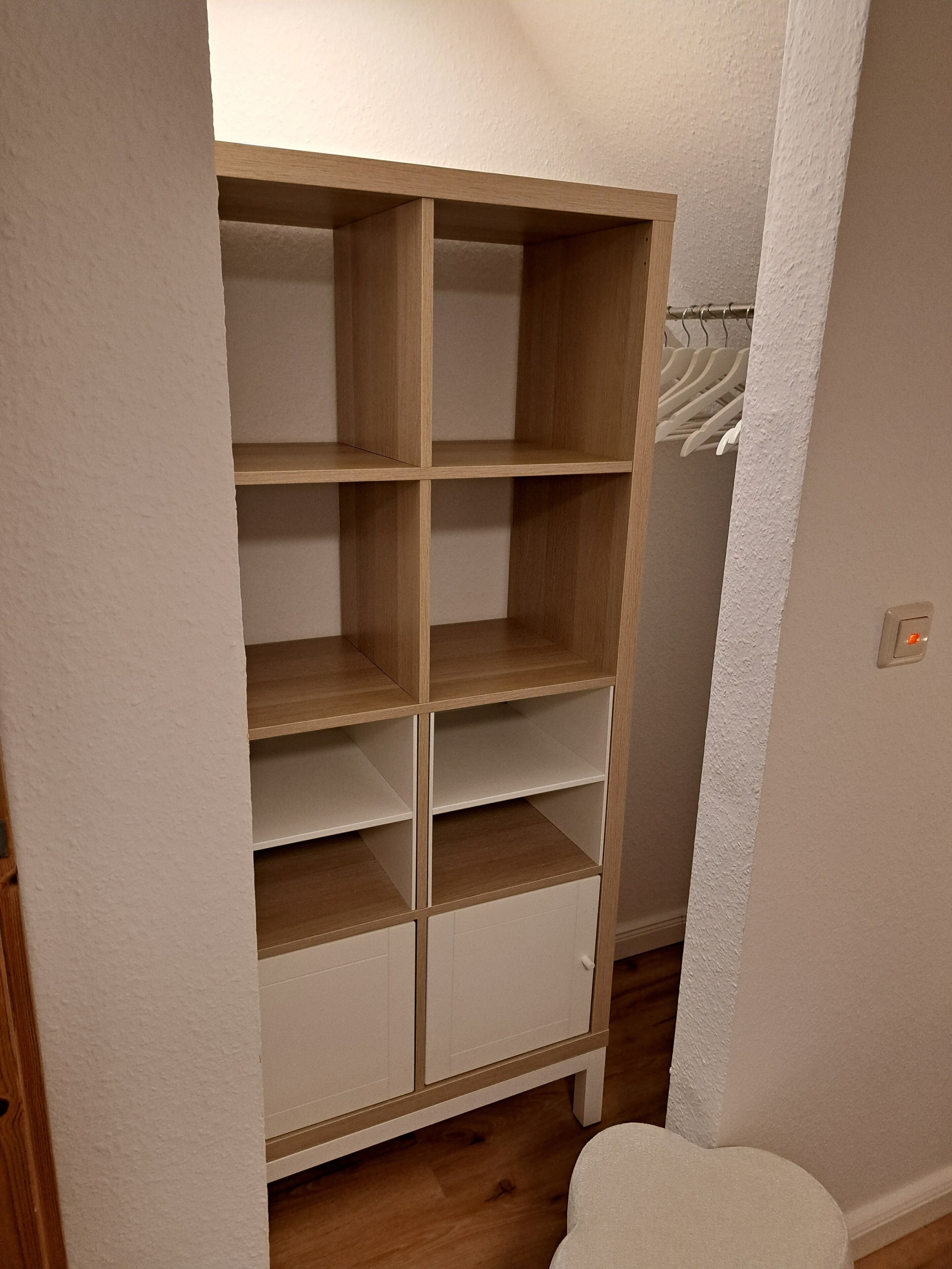 A closet with multiple shelves and hanging space.