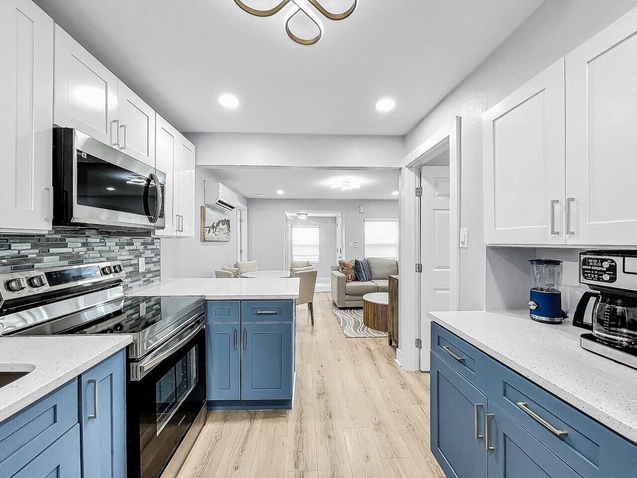 A modern kitchen with white cabinets, a central island, and stainless steel appliances.