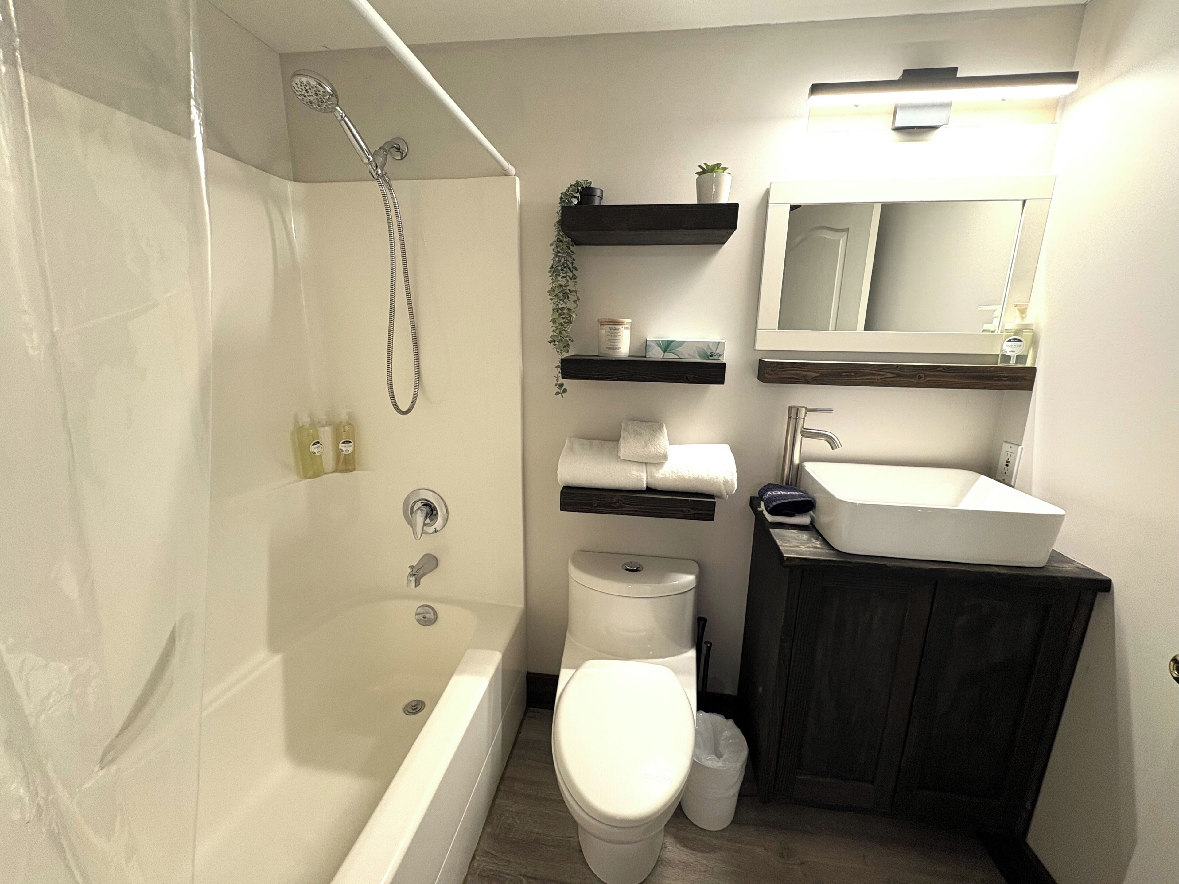 A bathroom with a bathtub, toilet, sink, and shower.