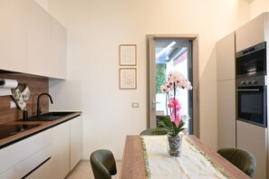 A modern kitchen with a wooden countertop, a sink, and a dining area with a table and chairs.