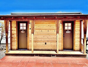 Un bâtiment en bois avec deux portes, une enseigne portant le nom « JONES » et un petit porche.