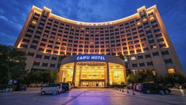 Un hotel con fachada curva, varios pisos y una entrada destacada.
