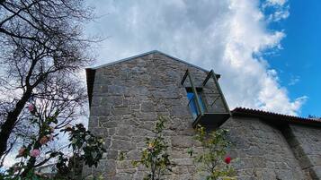 A stone building with a small balcony and a window.