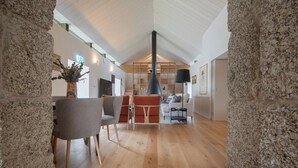A spacious living area with a high ceiling, a fireplace, and a modern seating arrangement. - Casa da Fonte de Cima (Celorico de Basto)